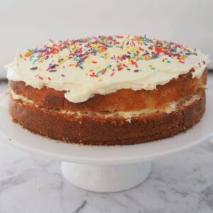 Butter cake with white buttercream on white cake stand