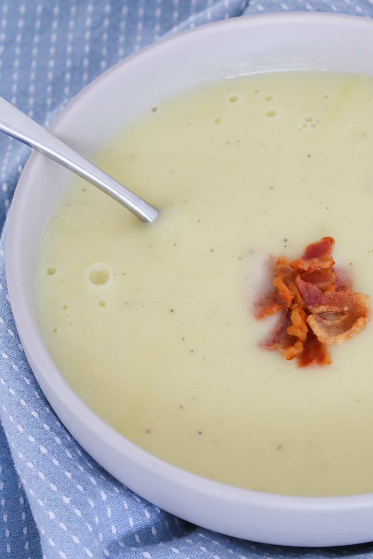 Bacon on top of a bowl of creamy vegetable soup.