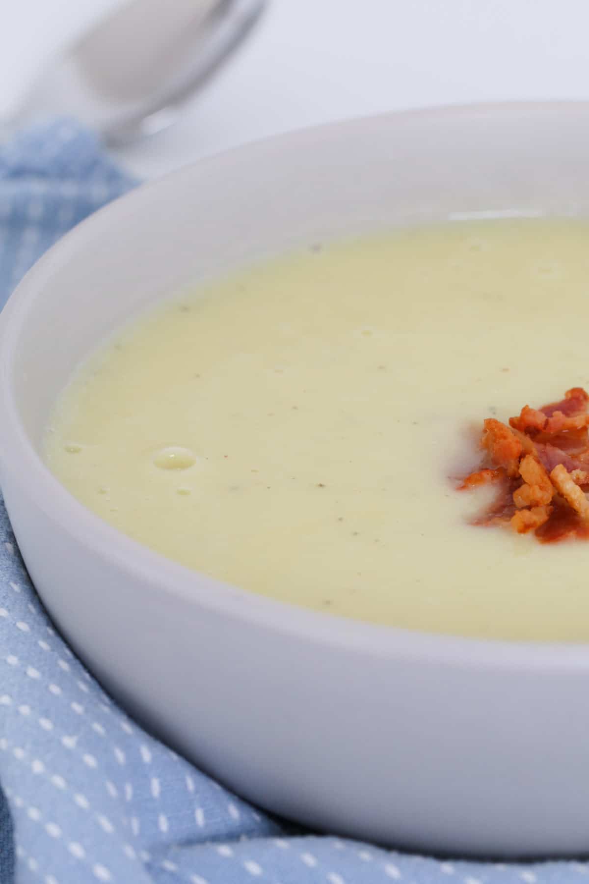 A bowl of cauliflower soup topped with crispy bacon.