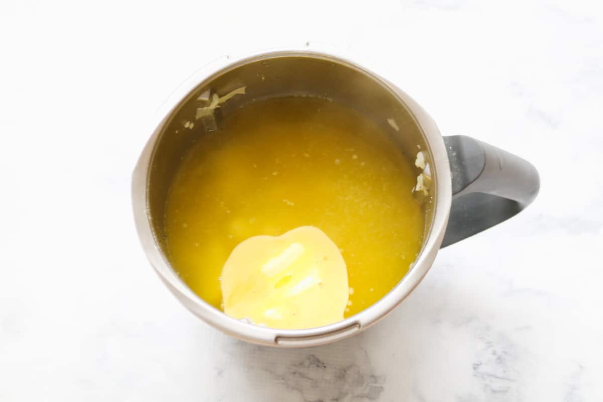Melted butter on top of hot soup in a stainless jug.