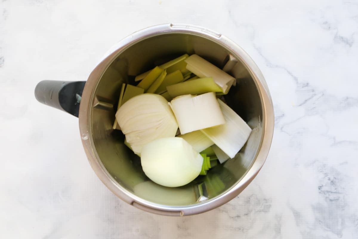 Onion and leek in a Thermomix bowl.