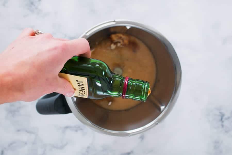 Whiskey being poured into a Thermomix bowl.