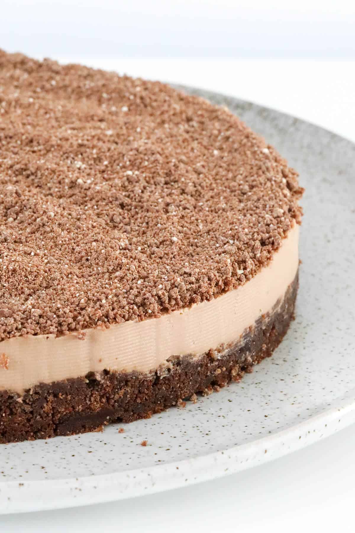 A close up of a chocolate cheesecake topped with grated Toblerone chocolate.