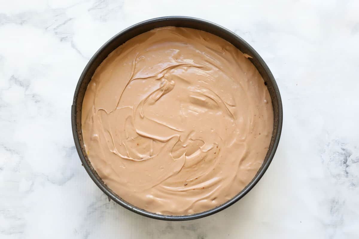 Chocolate cheesecake mixture in a round tin.