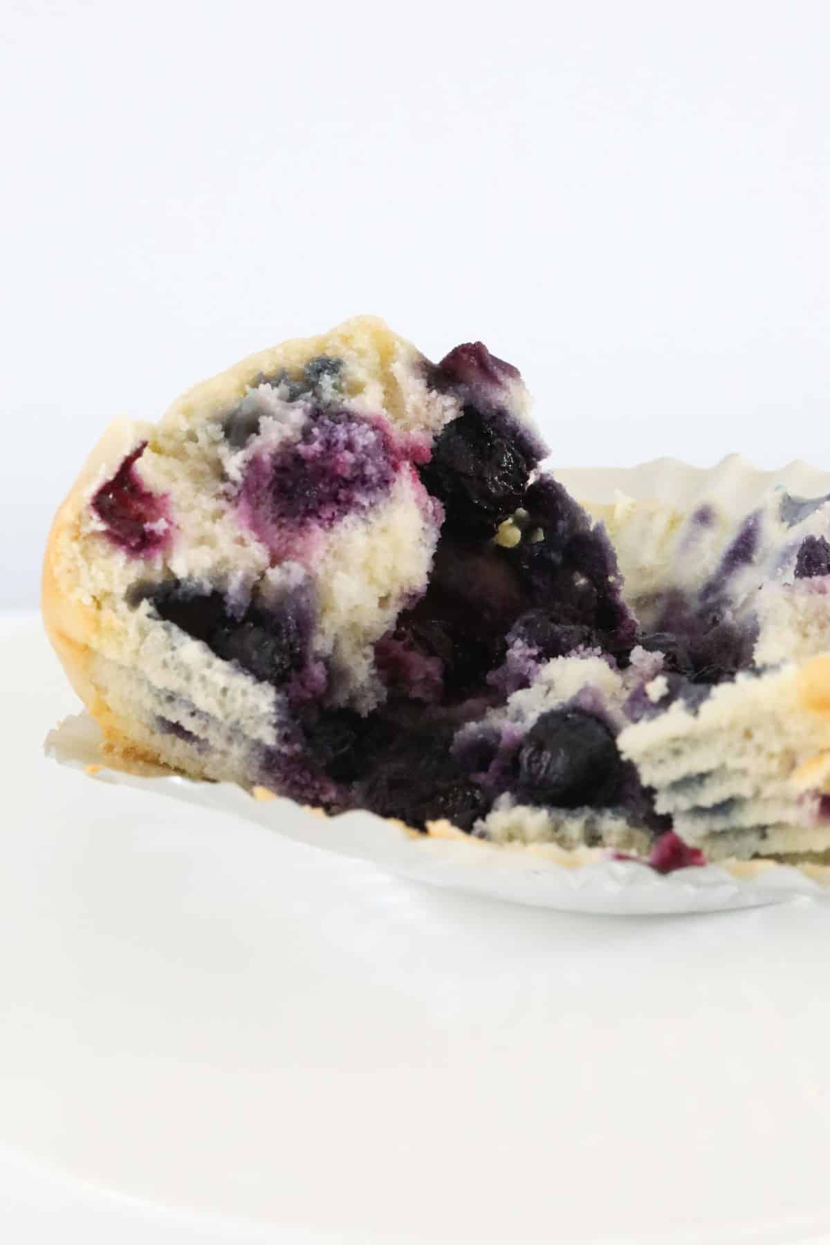 Half a muffin filled with blueberries.