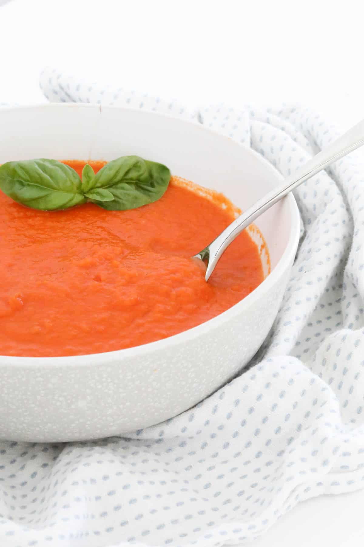 Tomato soup in a bowl with a spoon.
