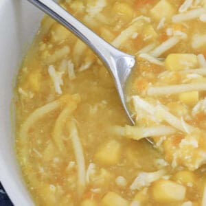 A chicken soup with vegetables and noodles in a bowl.