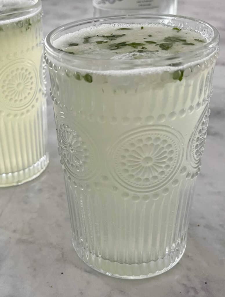 Two Thermomix Mojitos in decorative glasses on a marble top.