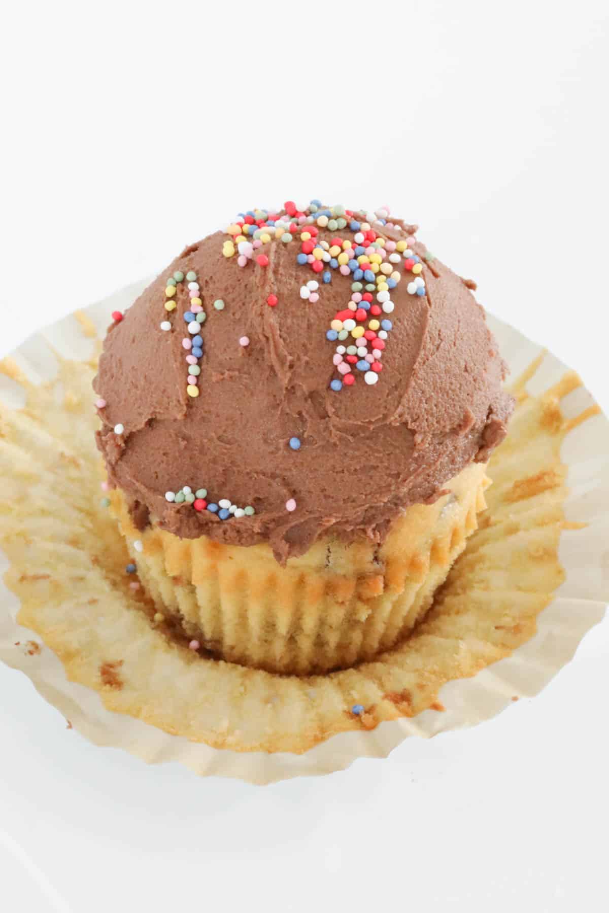 A cupcake coated in chocolate frosting.