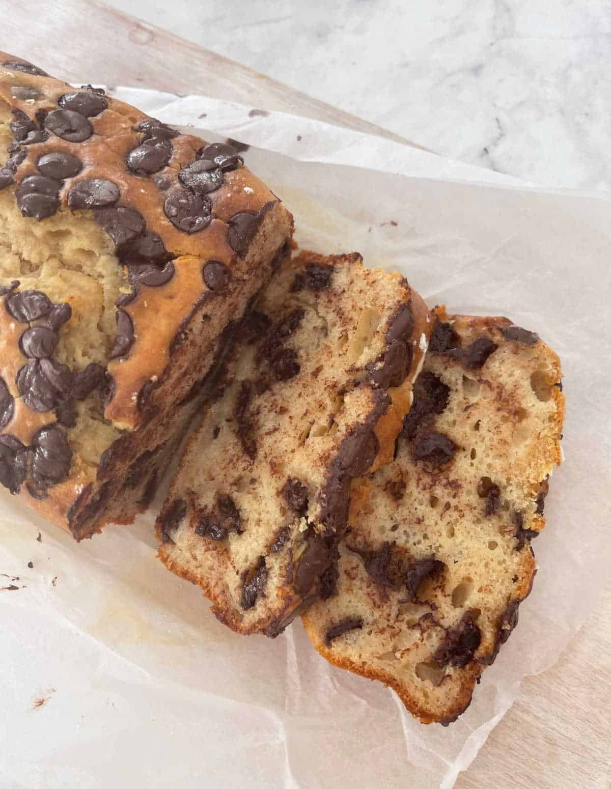 sliced chocolate chip banana bread on a wooden board.