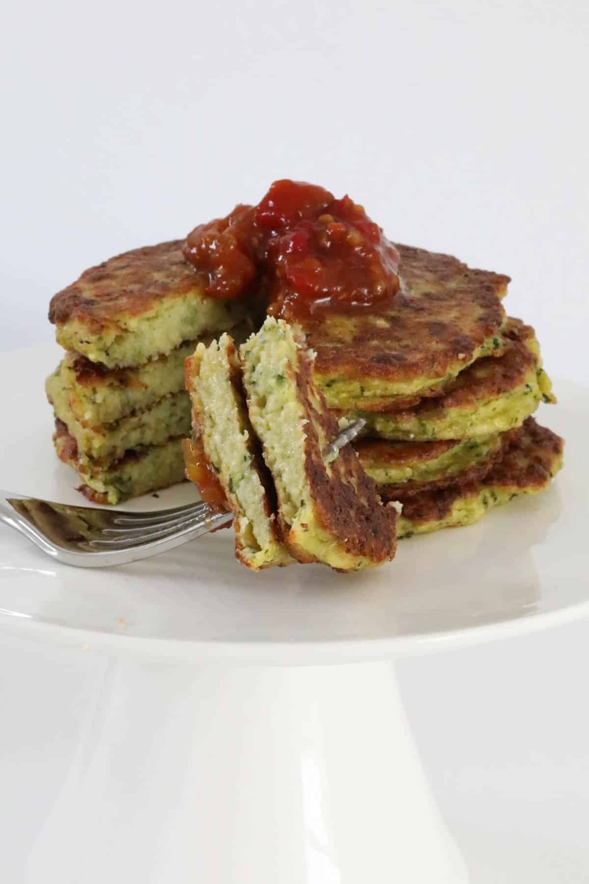 A stack of fritters with a forkful in front.
