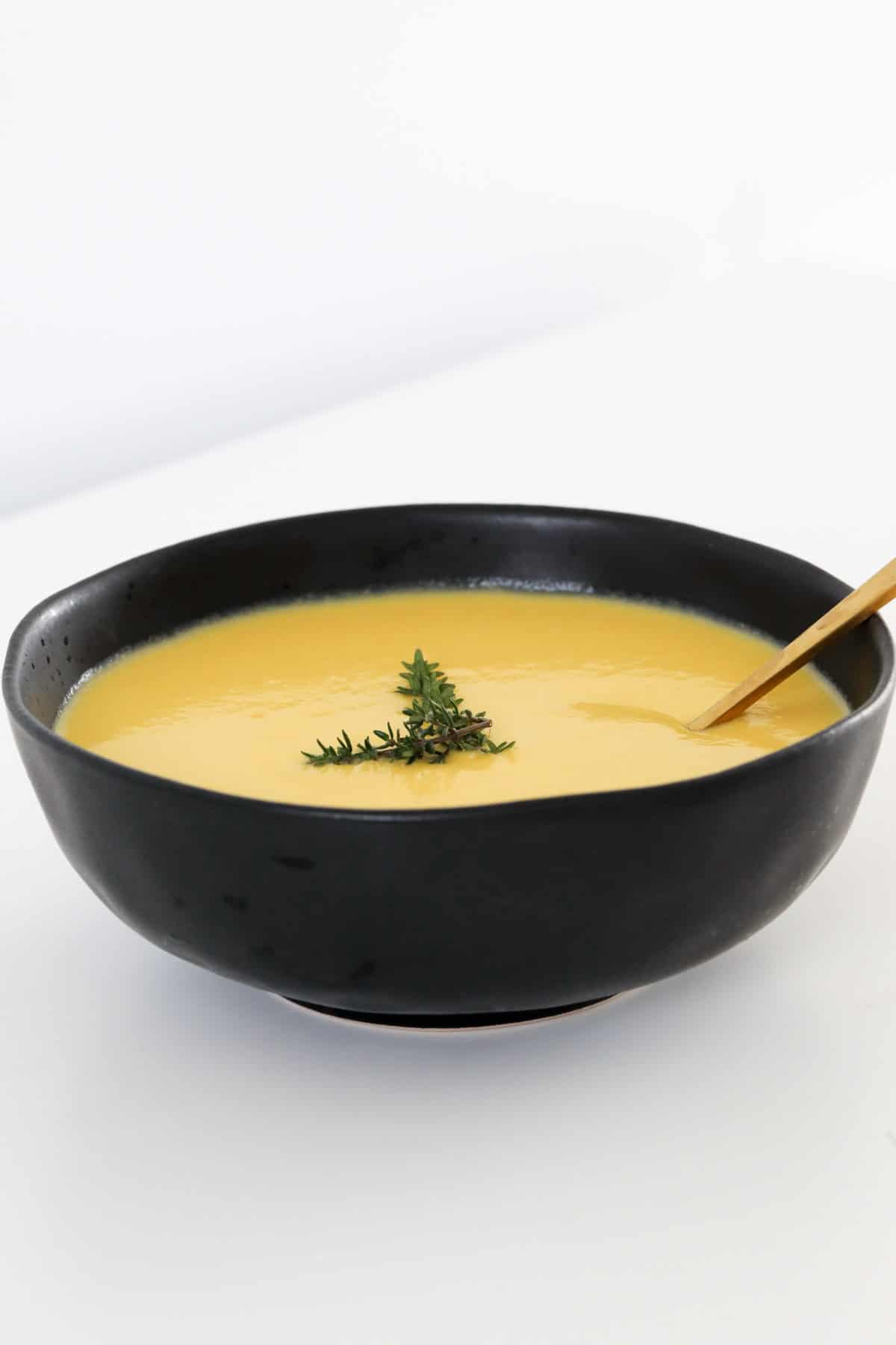 A black bowl filled with creamy chicken soup.