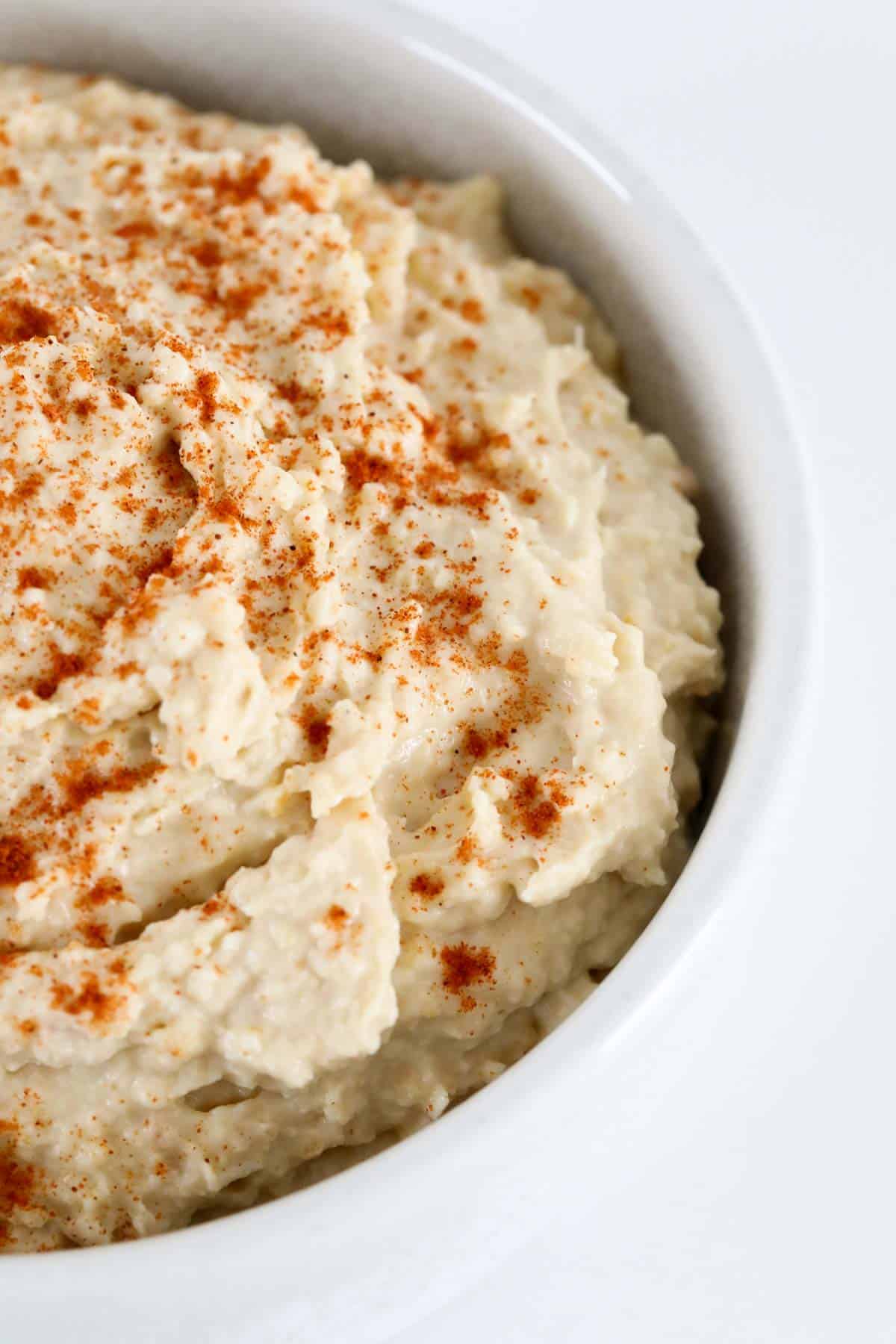 An overhead shot of hummus with paprika on top.
