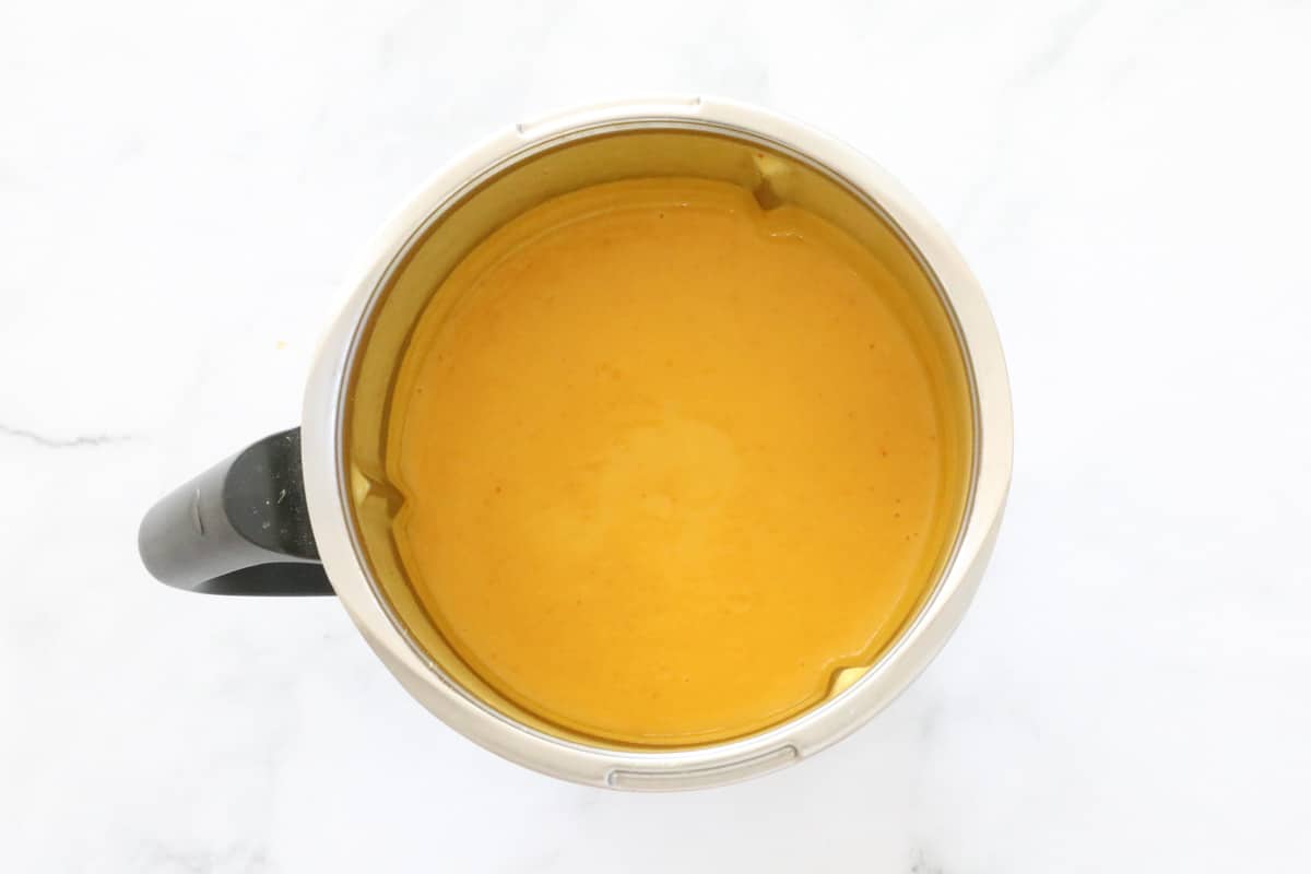 Smooth pureed thai pumpkin soup in a Thermomix bowl.