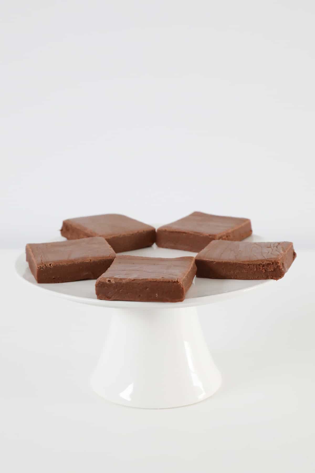 A cake stand topped with chocolate fudge.