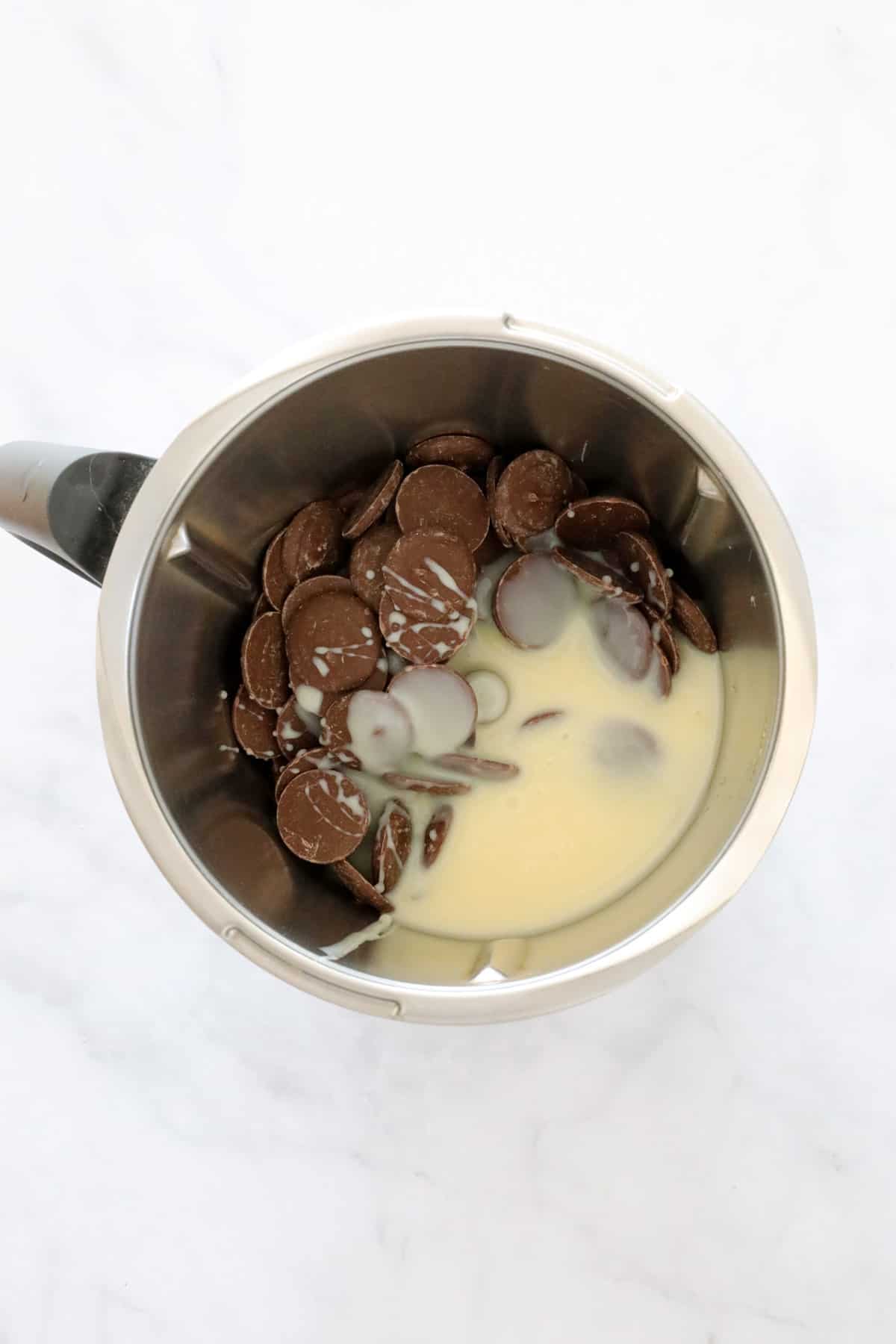 Sweetened condensed milk and chocolate in a Thermomix bowl.