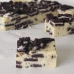 slices of Oreo fudge on a piece of white baking paper and white bench top.