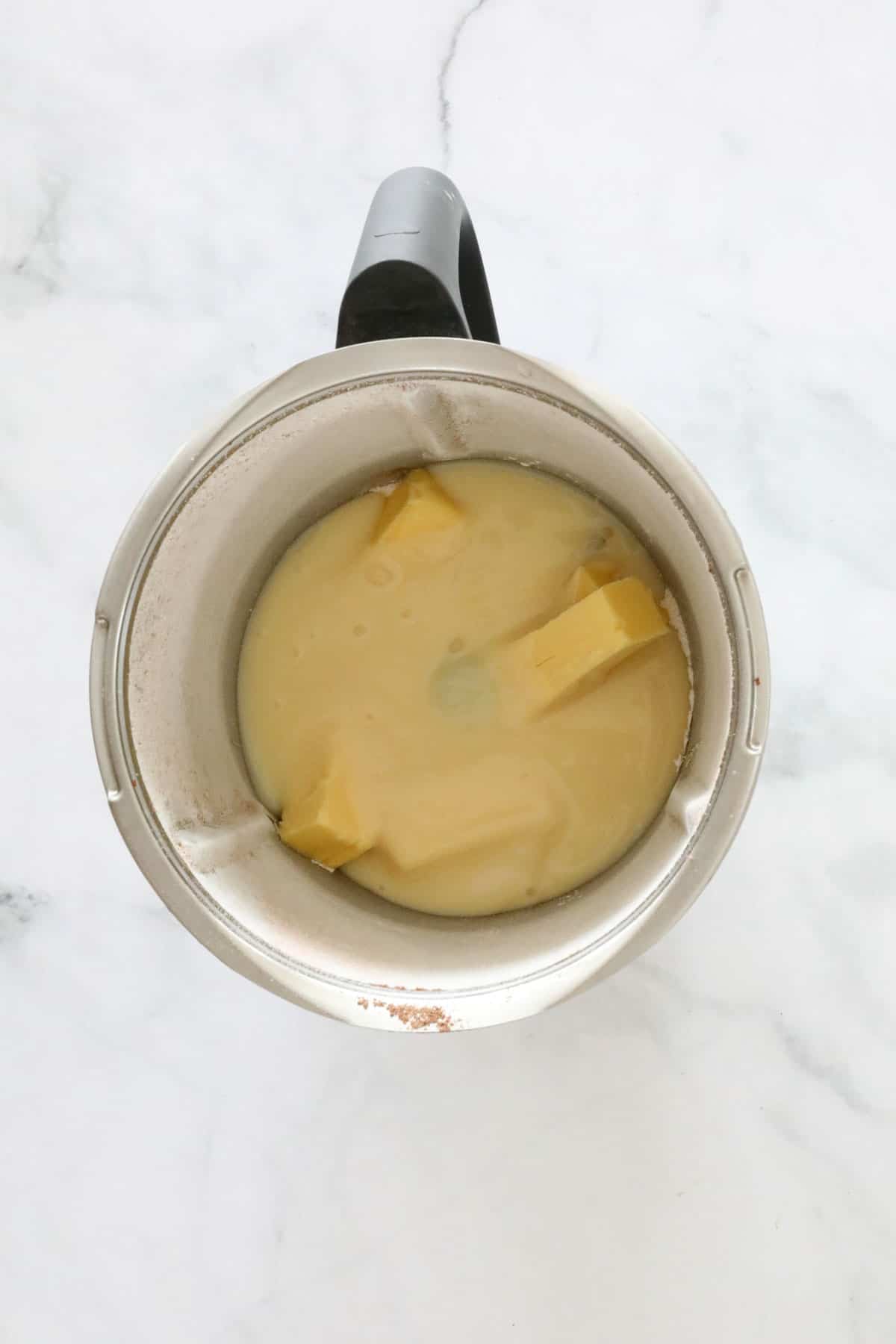 Sweetened condensed milk and butter in a Thermomix jug.