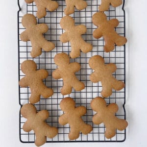 Baked gingerbread biscuits on a wire rack.