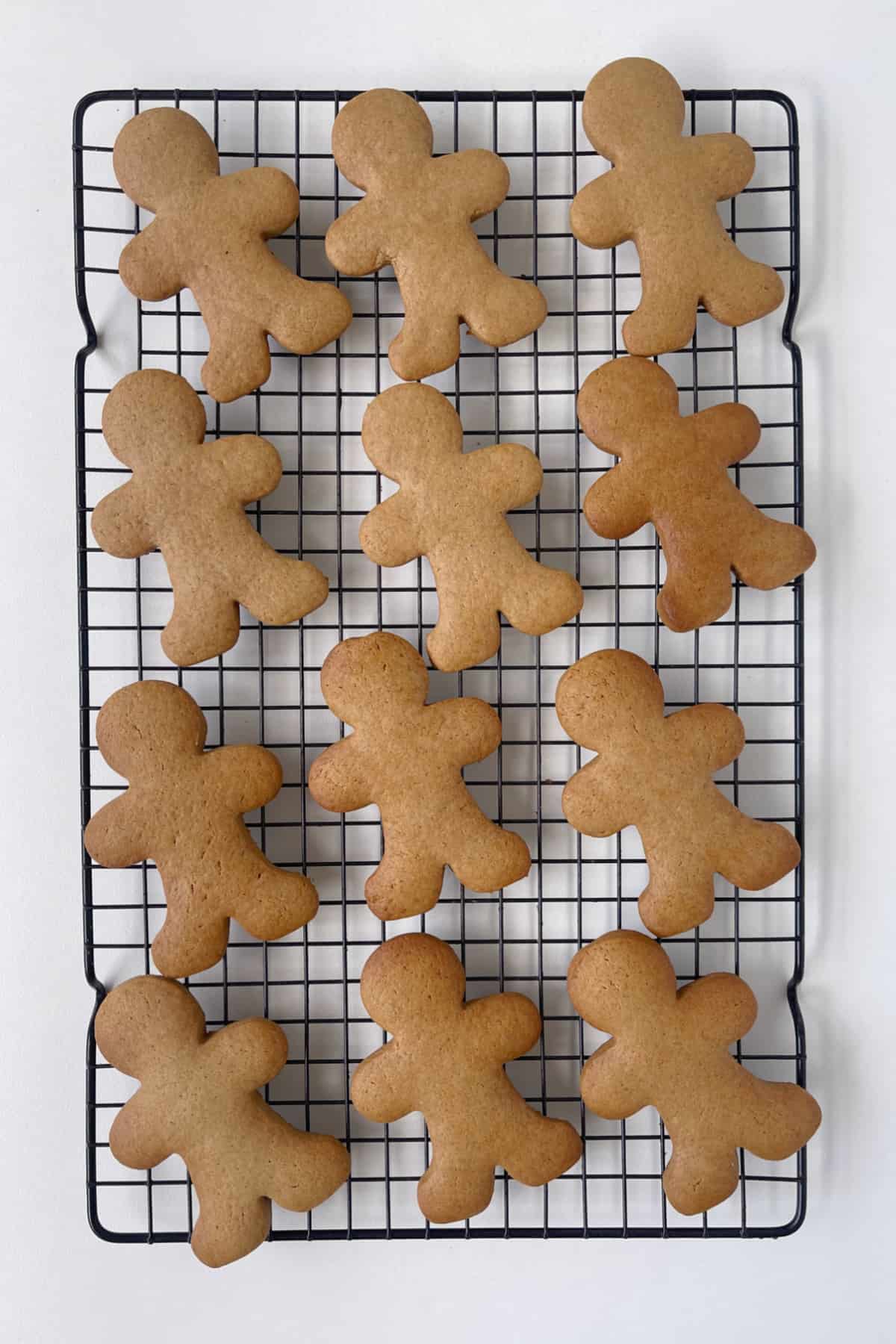 Baked gingerbread biscuits on a wire rack.