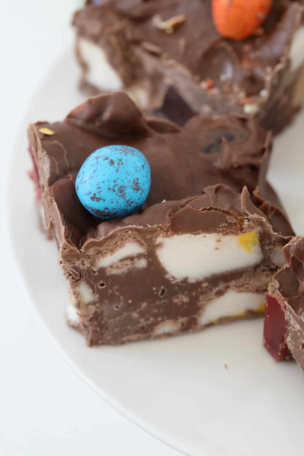 An easter egg on top of a piece of chocolate marshmallow slice.