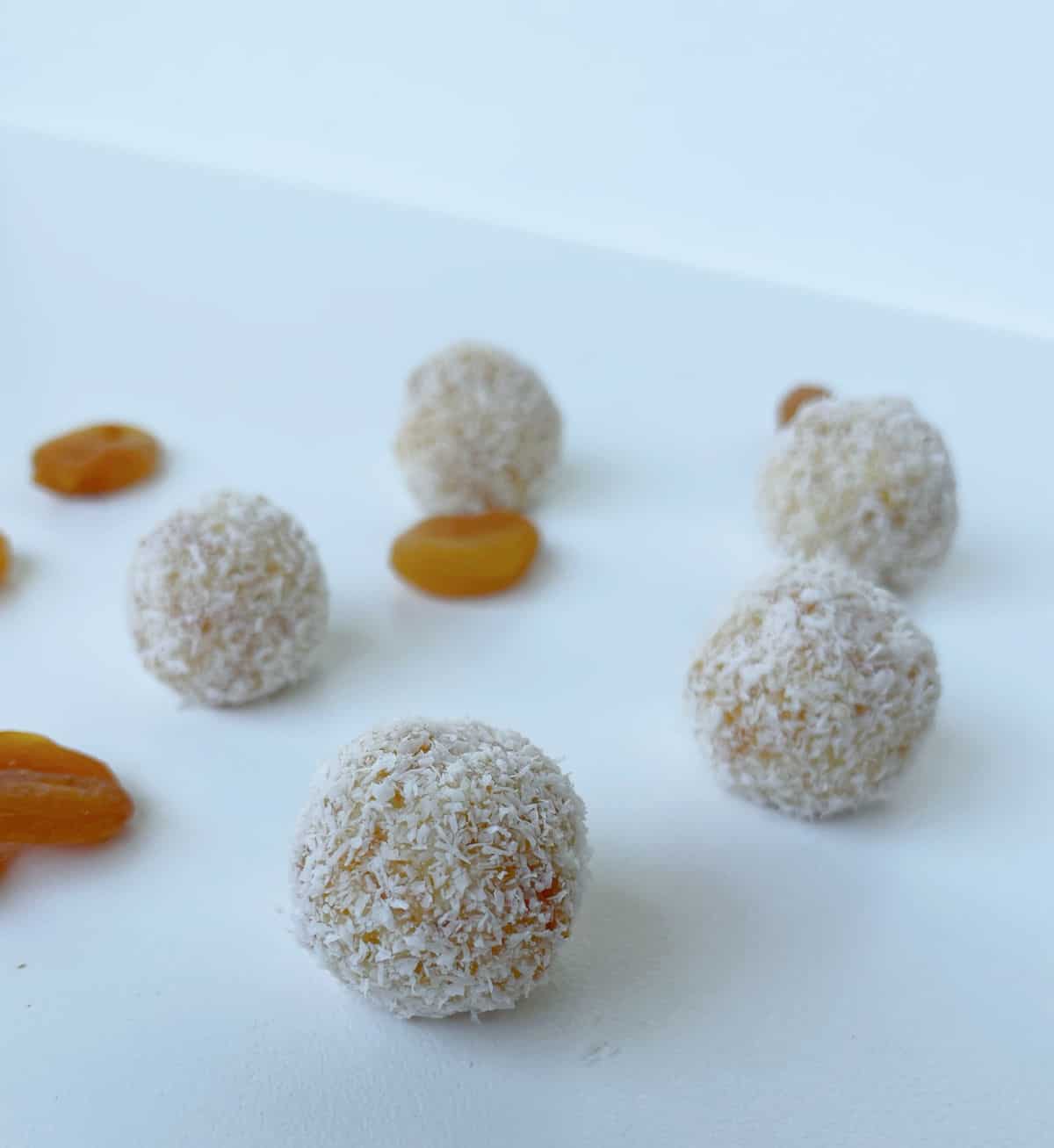 apricot and coconut balls on white background.