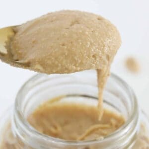 Smooth peanut butter falling off a spoon.