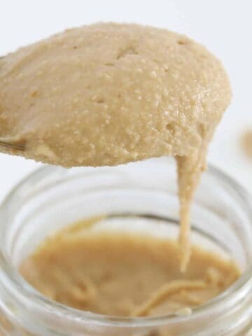 Smooth peanut butter falling off a spoon.