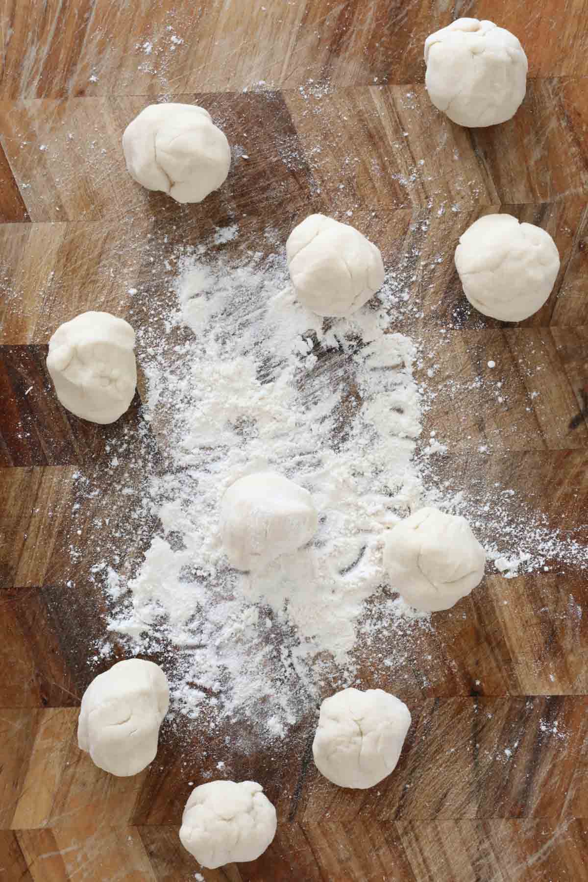 Small balls of dough on a chopping board.