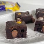 Pieces of Brownies with Easter egg stacked on a white plate.