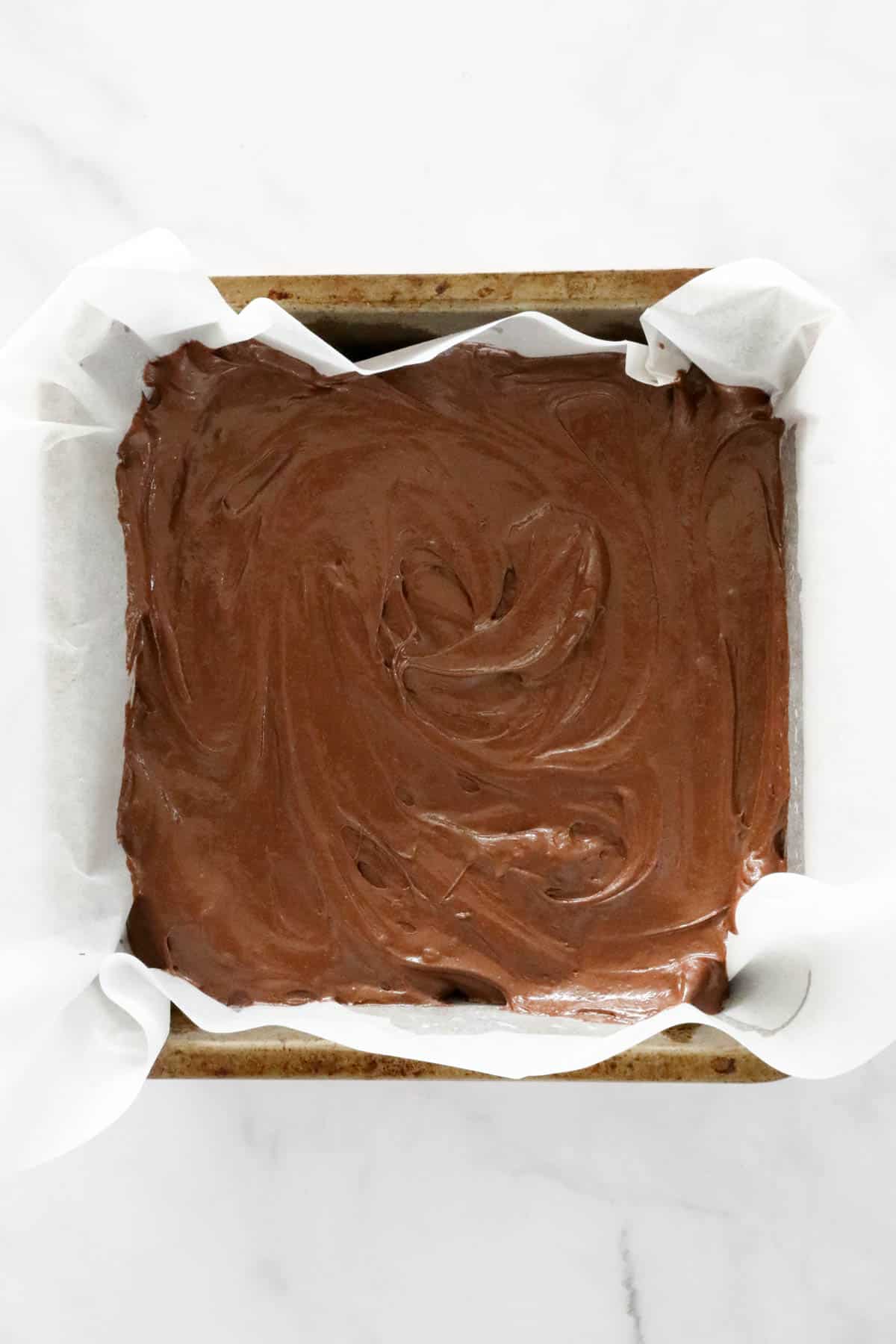 Brownie batter in a square tin.