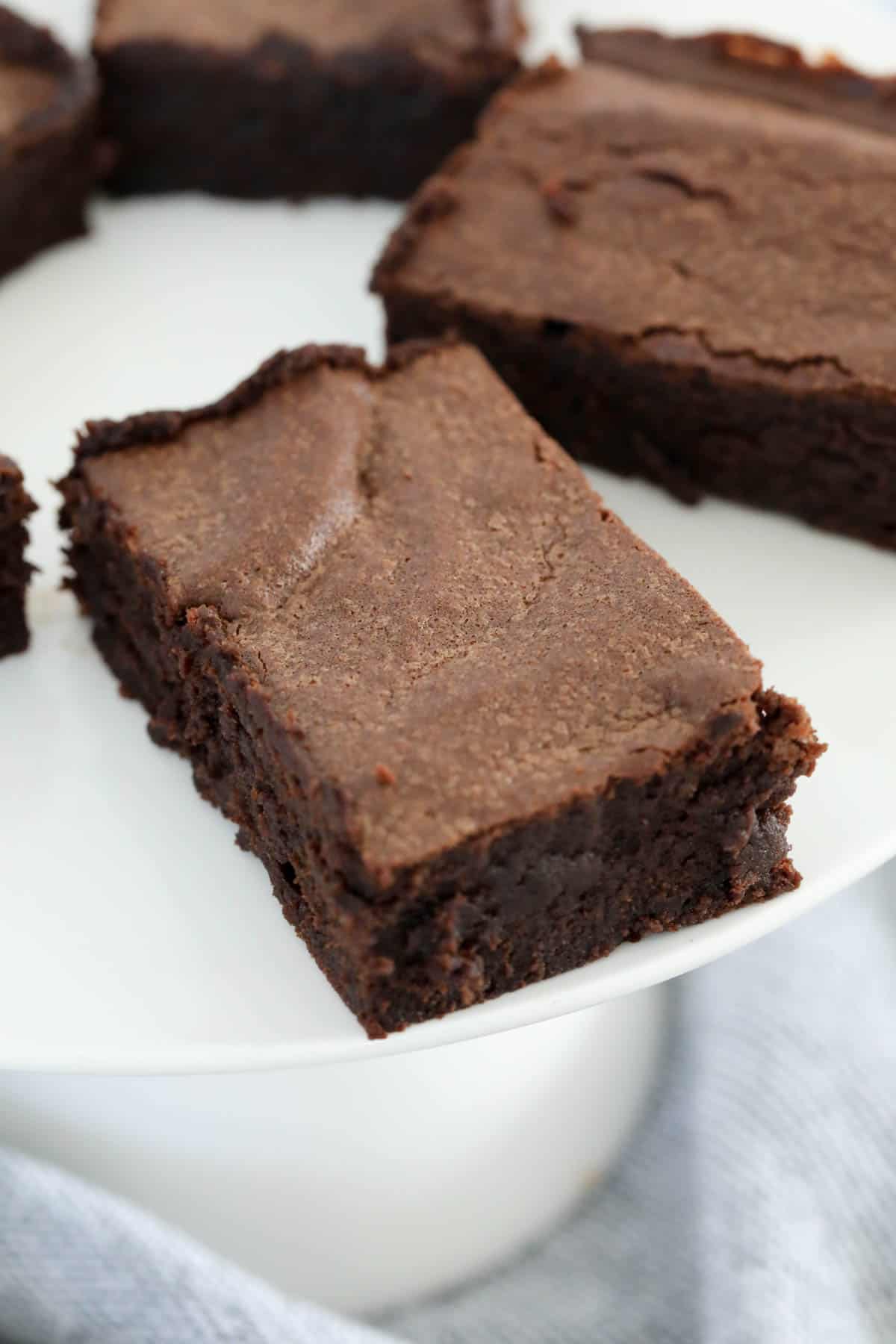 A flakey topped brownie on a plate.