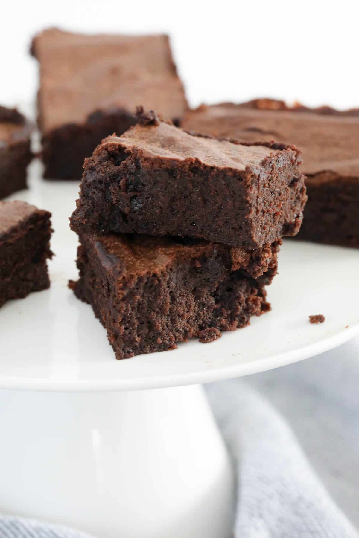 Chunky rich brownies on a white plate.