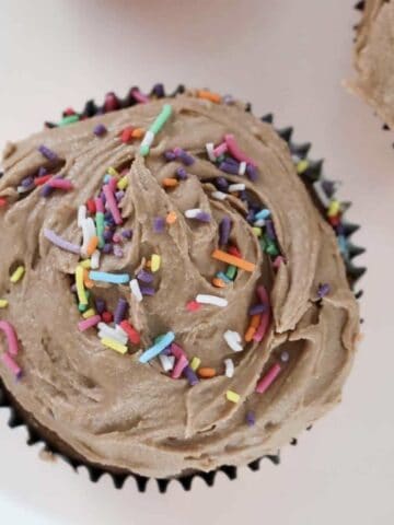An overhead shot of chocolate cupcakes with frosting.