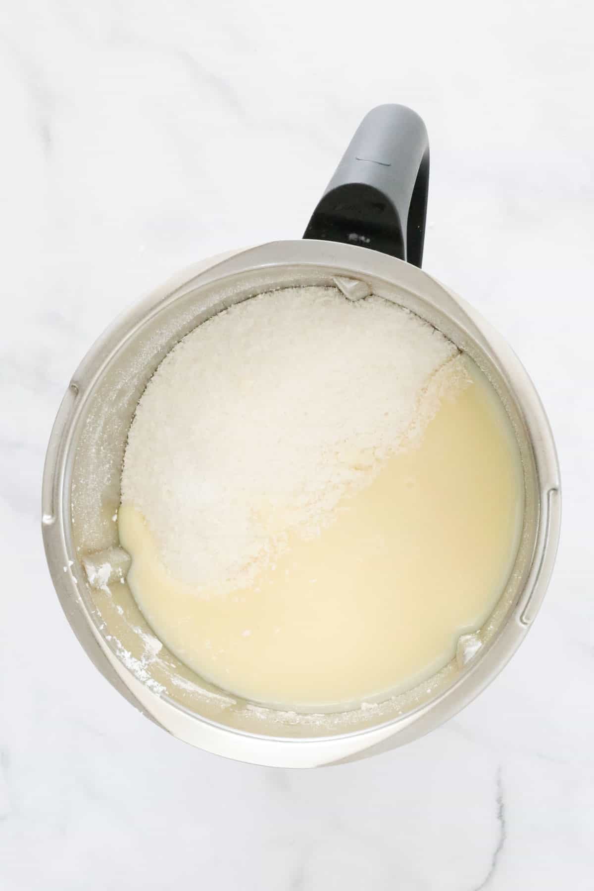 Sweetened condensed milk and coconut in a Thermomix bowl.