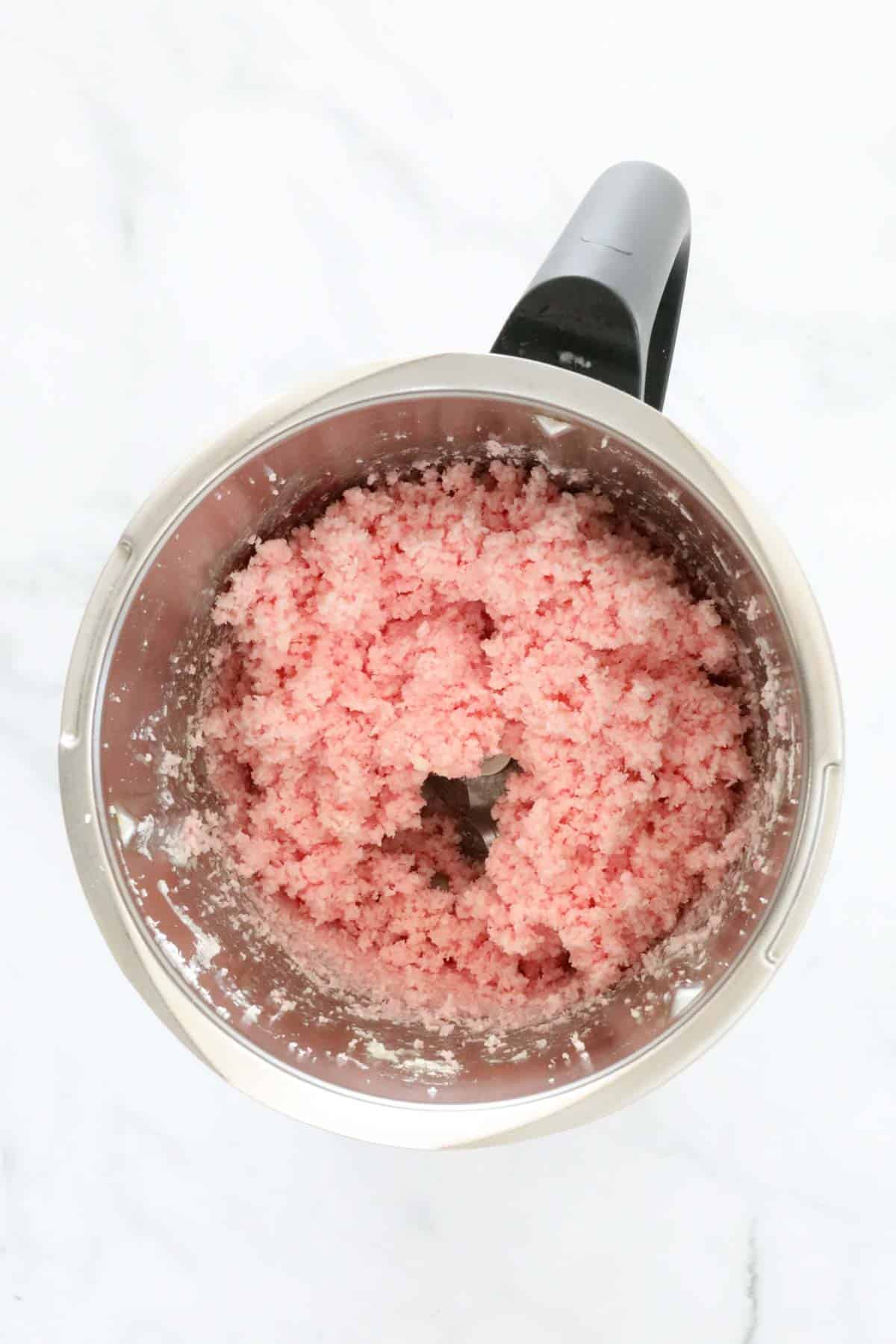 Pink coconut mixture in a Thermomix bowl.