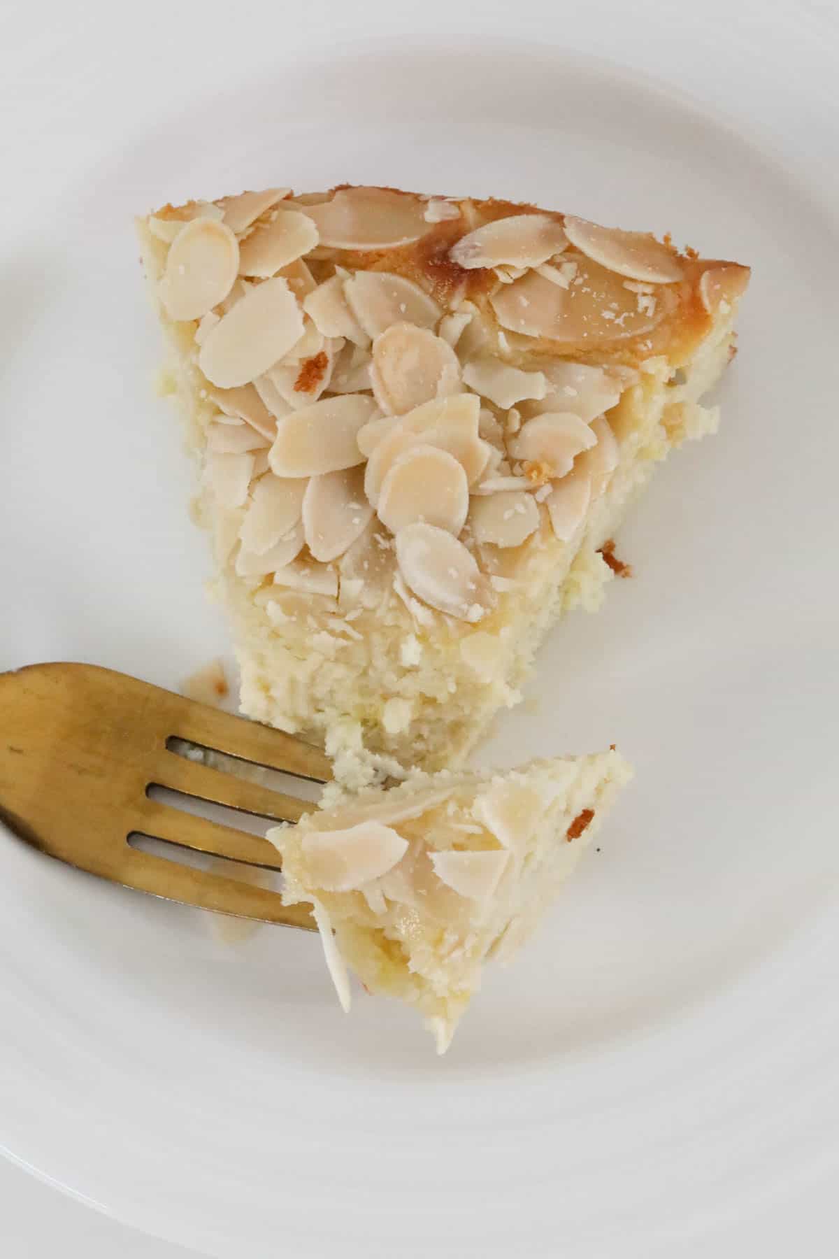 An overhead shot of a piece of almond topped cake.