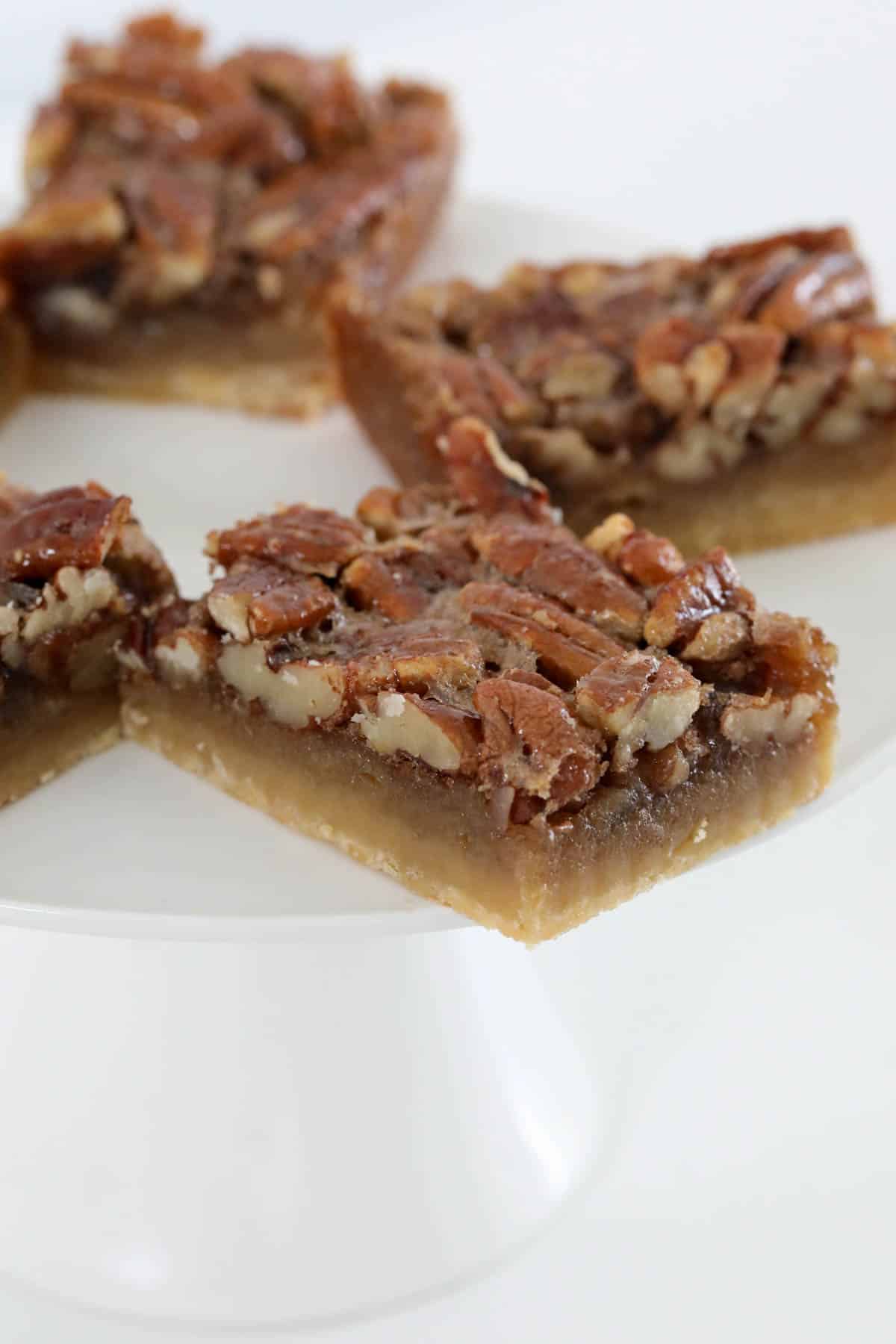 Pieces of pecan slice on a cake stand.