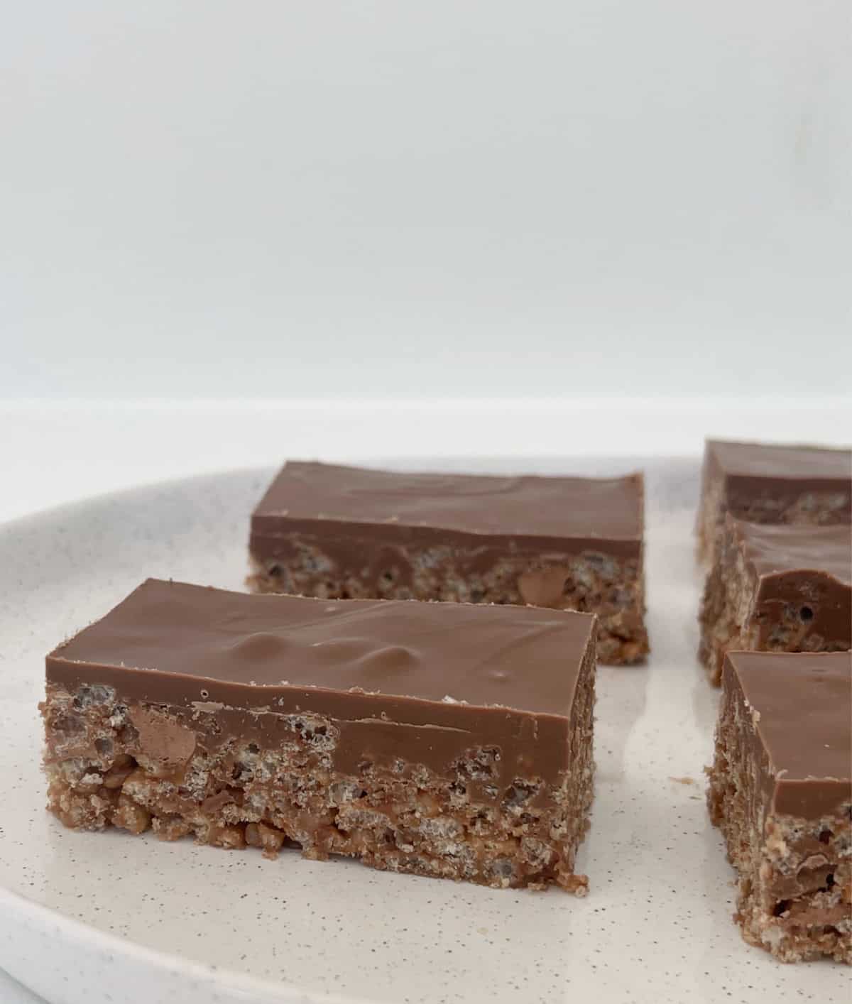 Side view of Mars Bar Slices pieces sitting on a white serving tray.
