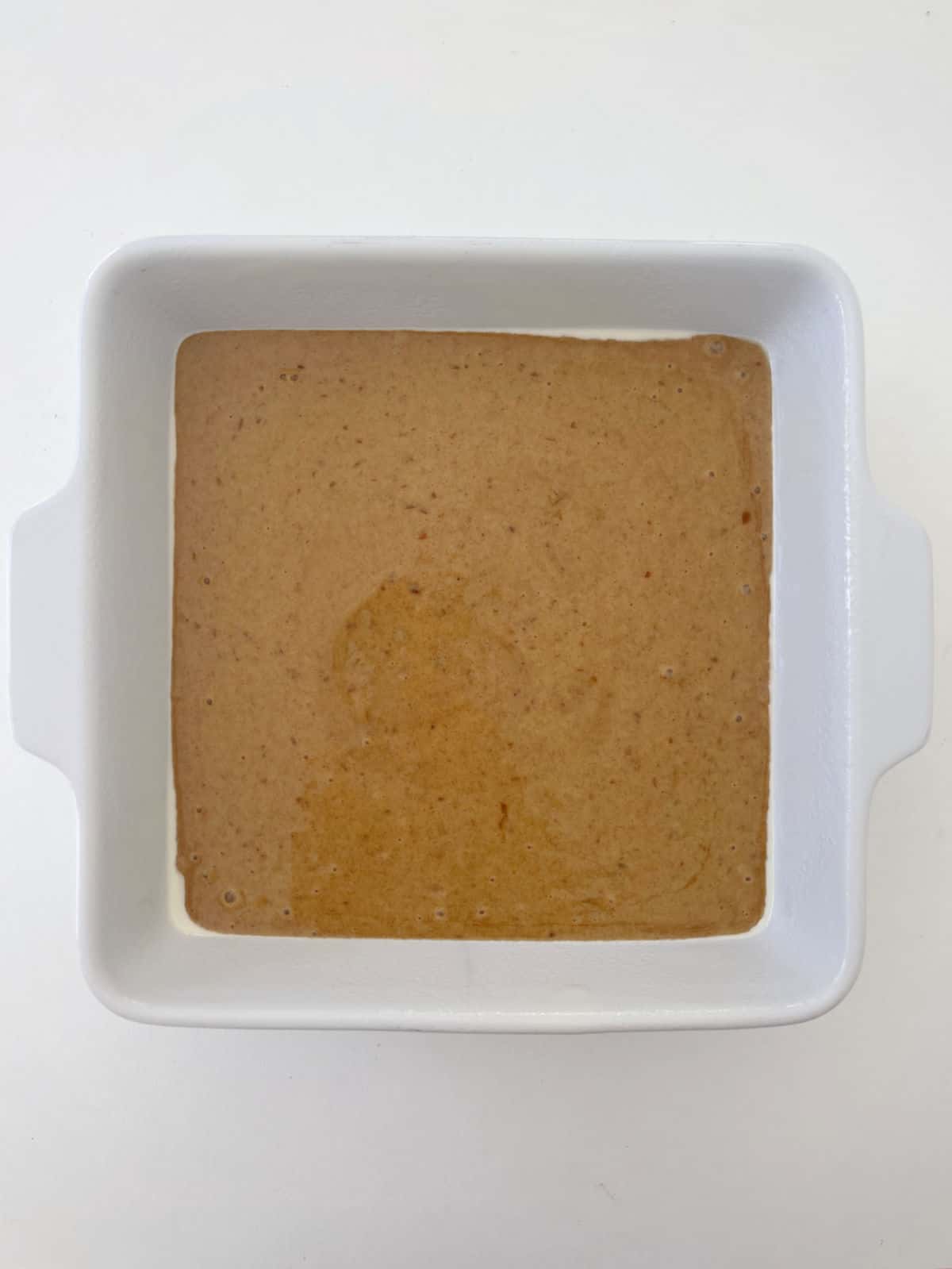 Sticky Date Pudding mixture in a white square baking dish.