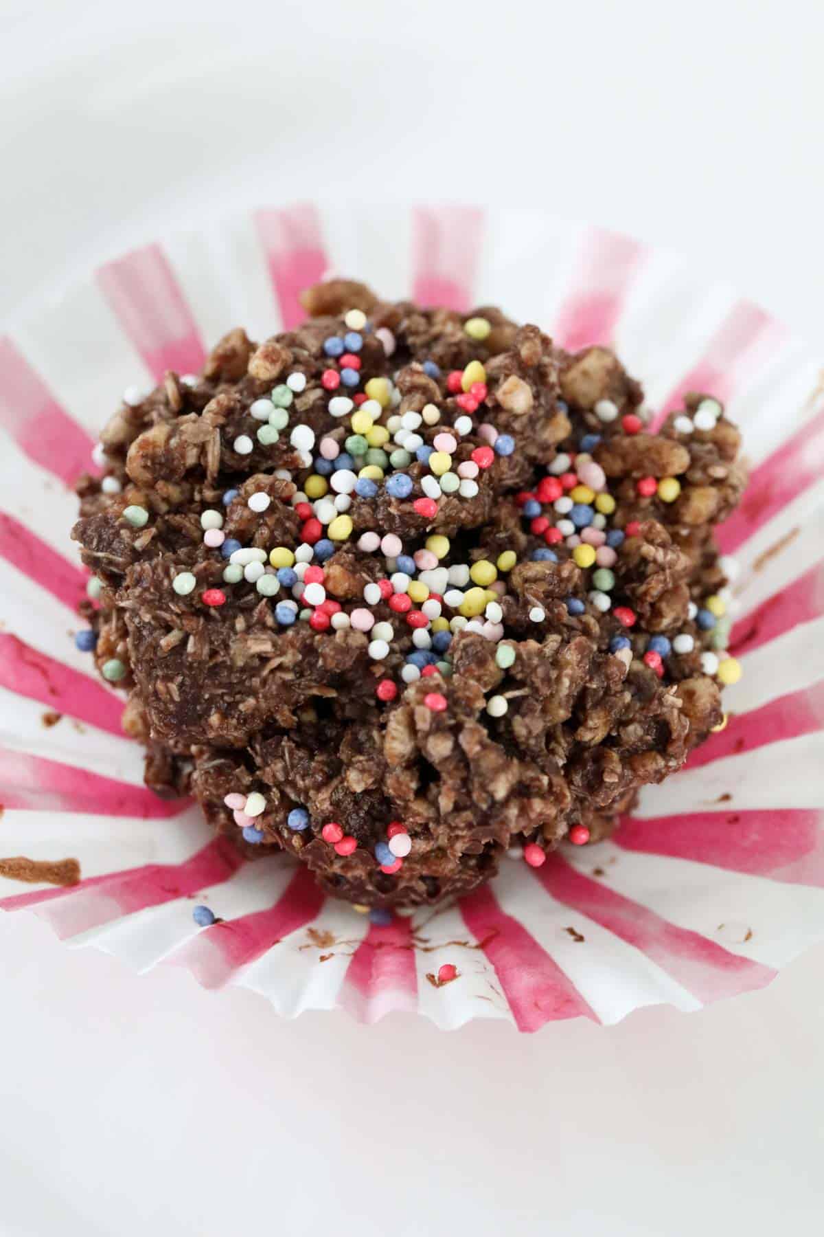 A chocolate crackle with sprinkles on top.