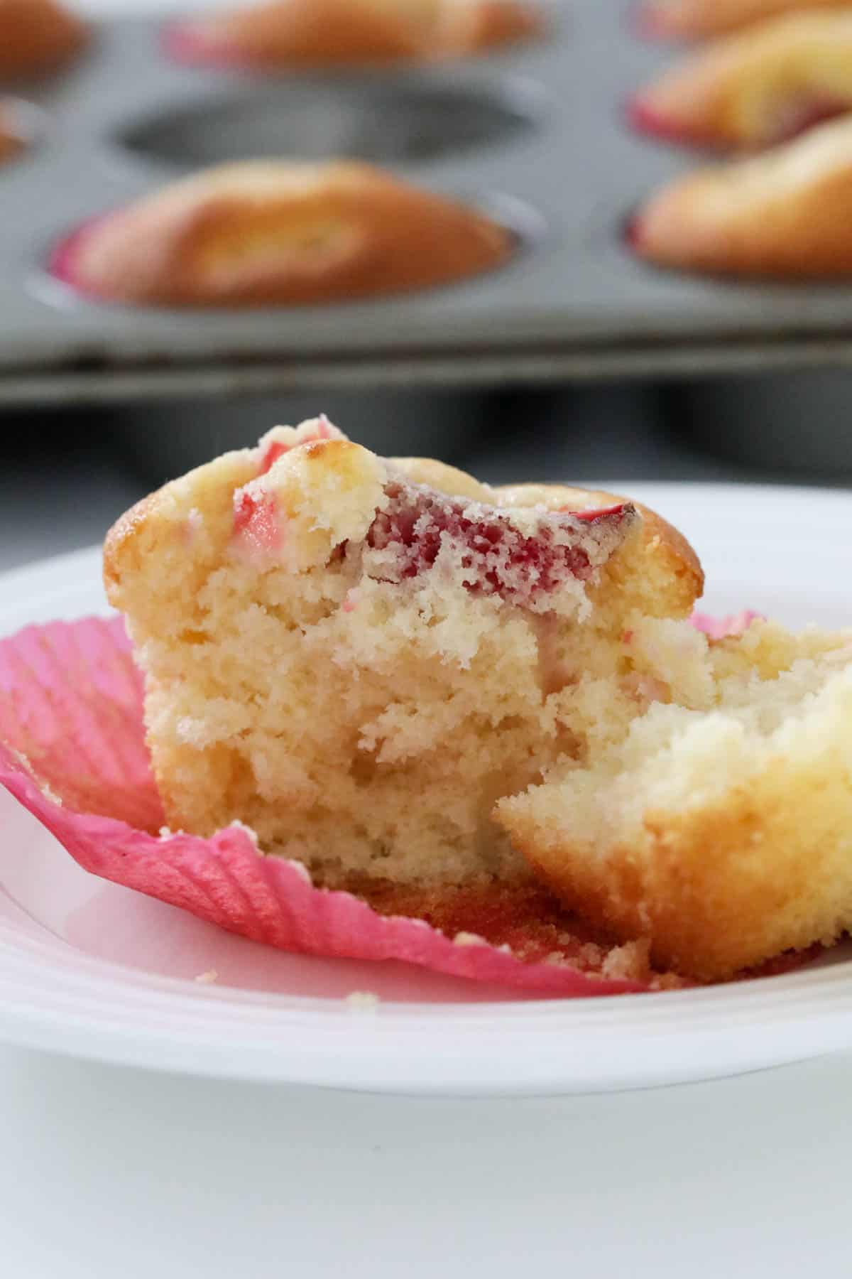 A half eaten strawberry cupcake.