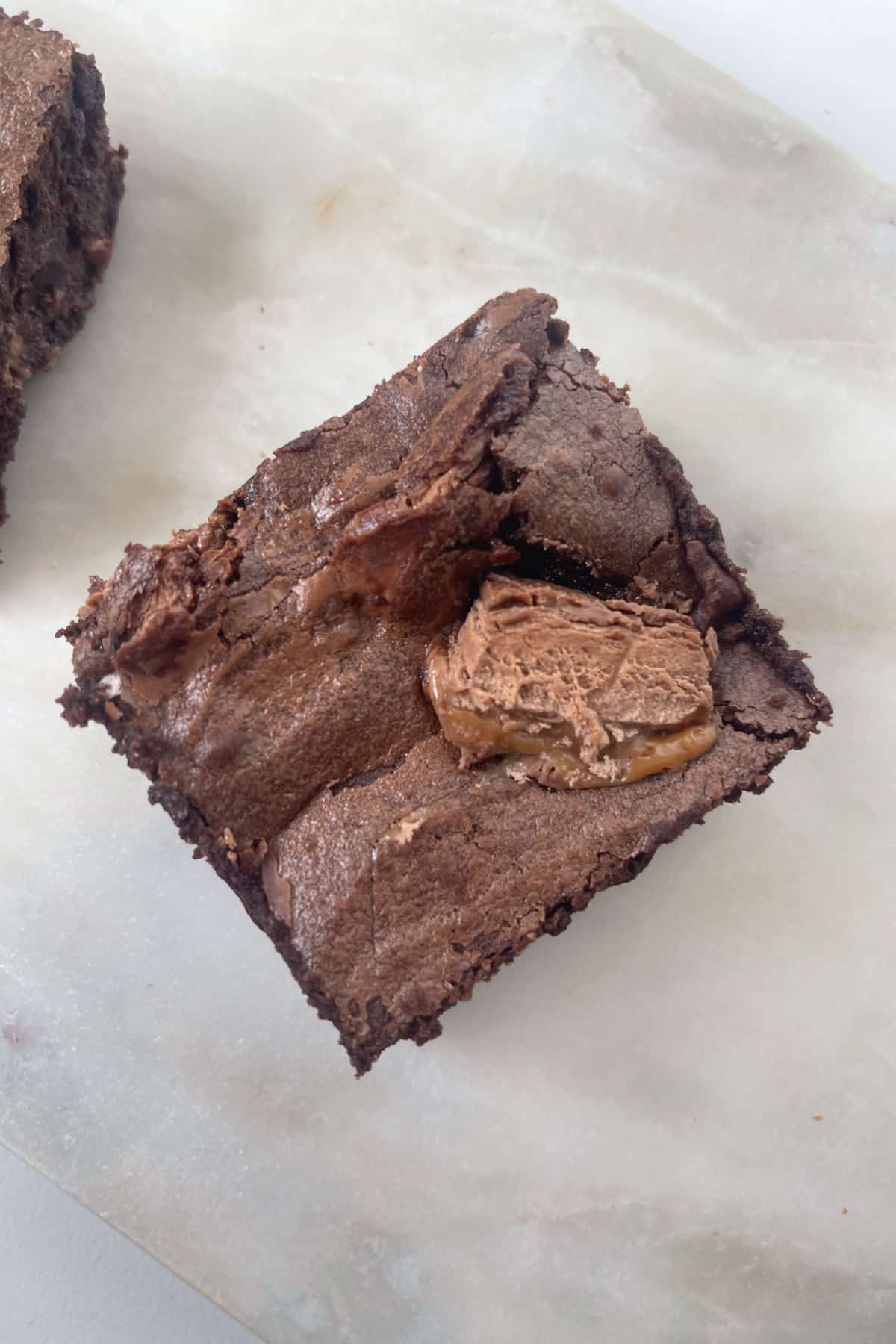 Overhead view of a piece of Mars Bar Brownie sitting on a stone serving tray.