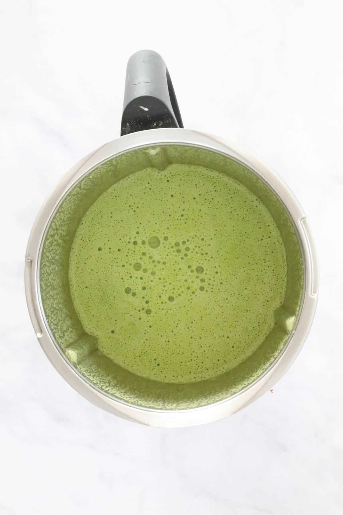 A Thermomix filled with green liquid.