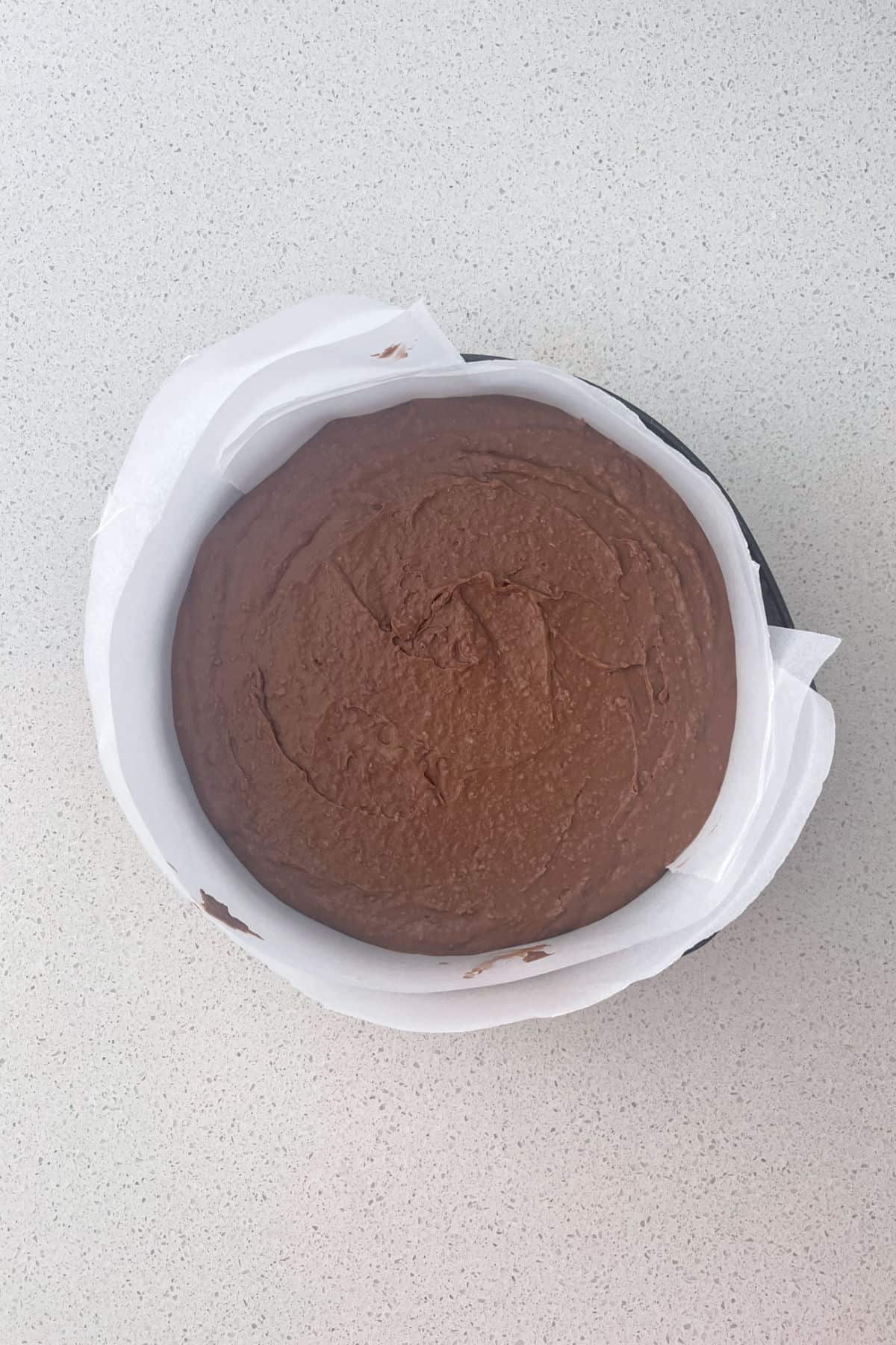 Thermomix chocolate and coconut cake mixture in a cake tin ready for the oven.