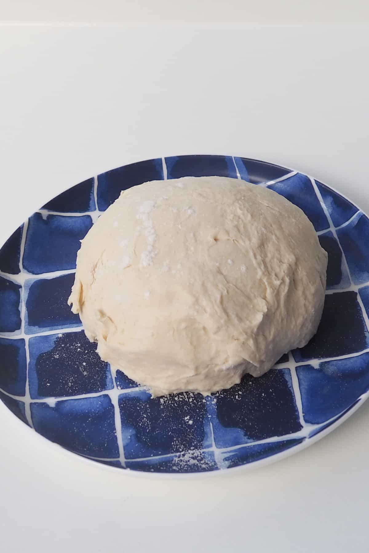 overhead view of 2 ingredient dough sitting on a blue striped plate.