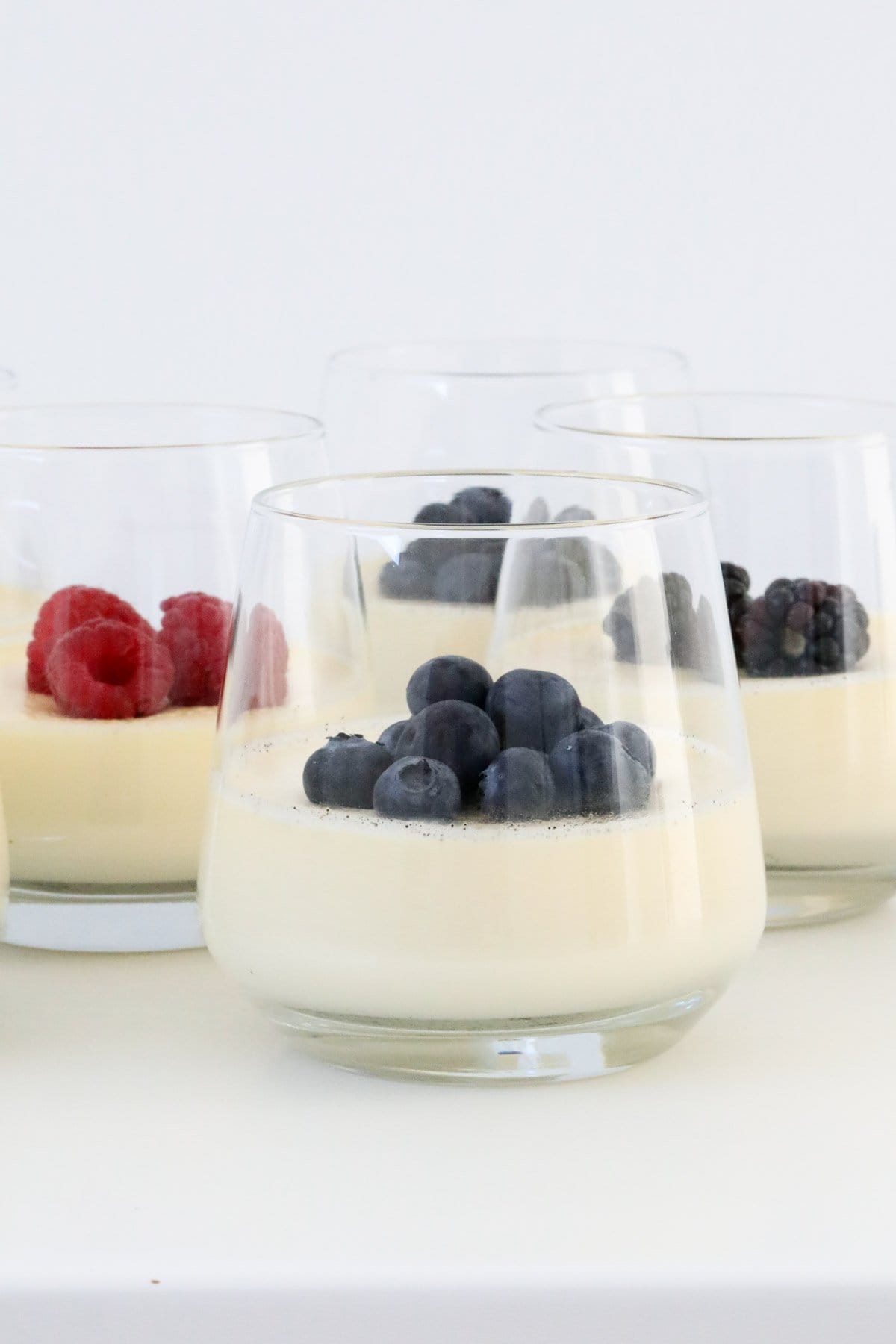 Glasses filled with panna cotta and berries.