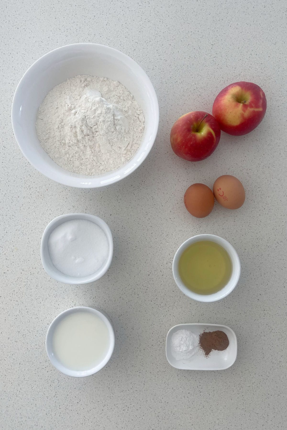 Ingredients for Thermomix Apple Muffins recipe on a white speckled bench.