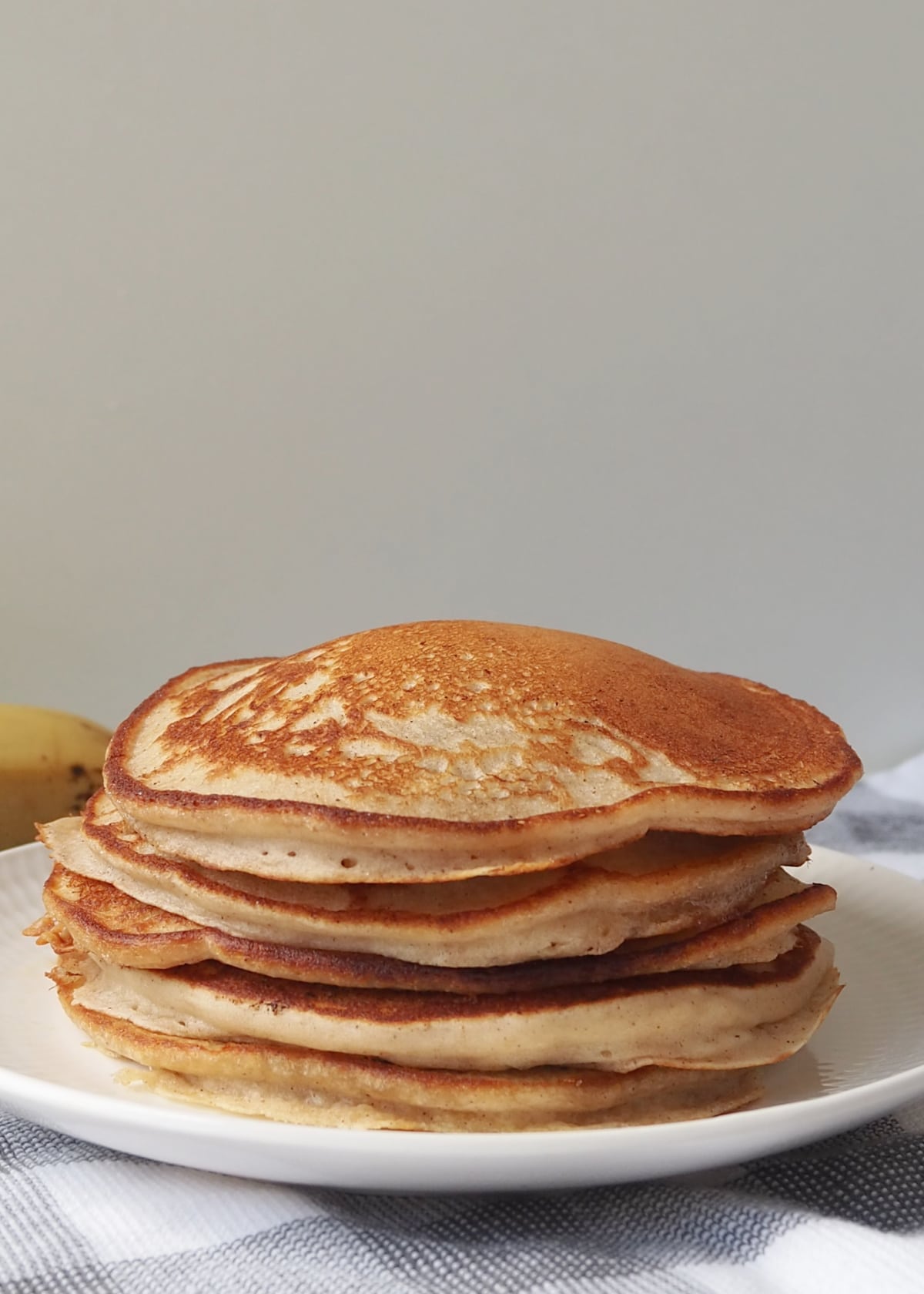 Centred view of Stack of banana pancakes sitting on a white pate.