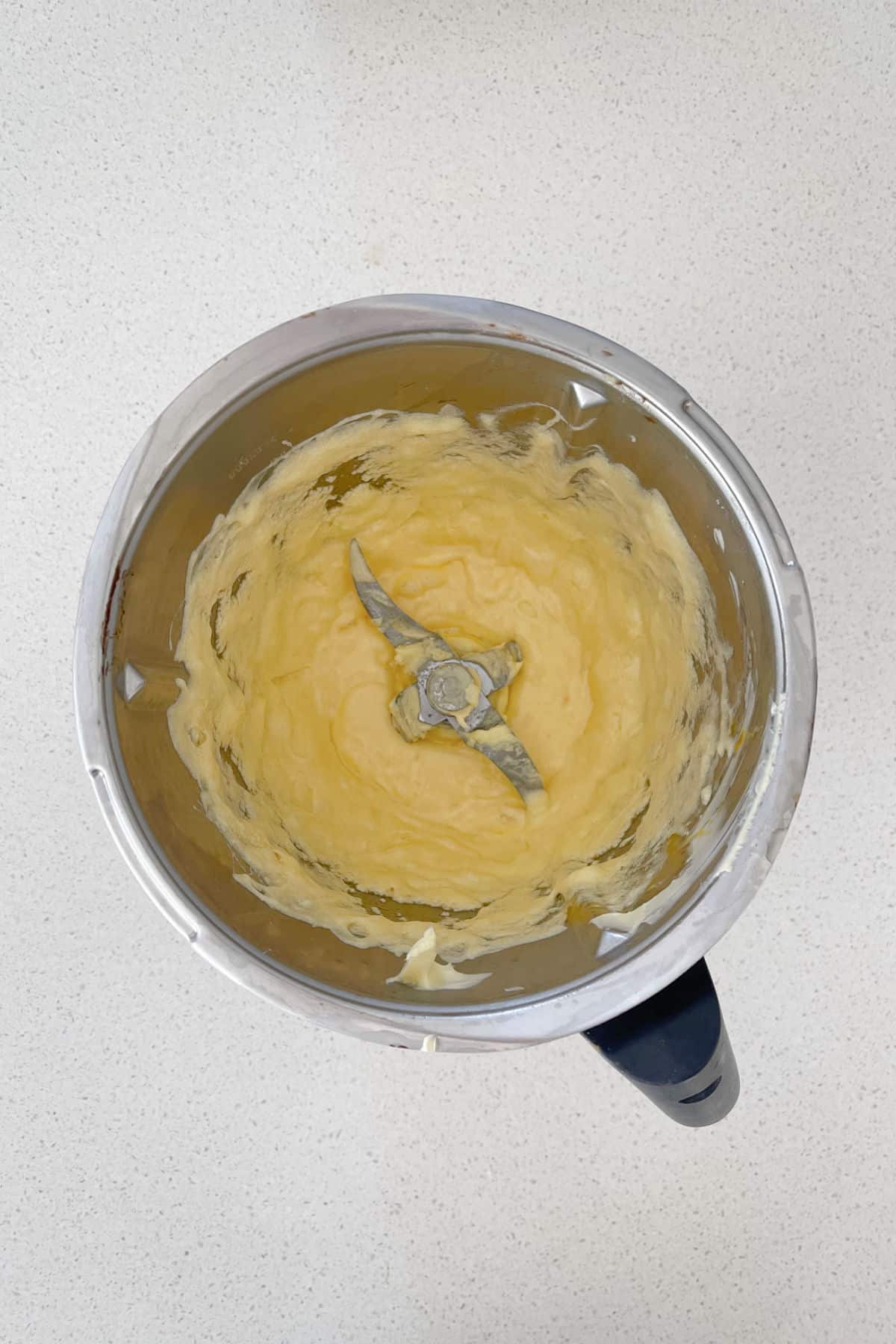 Creamed butter and sugar combined with eggs in a thermomix bowl.